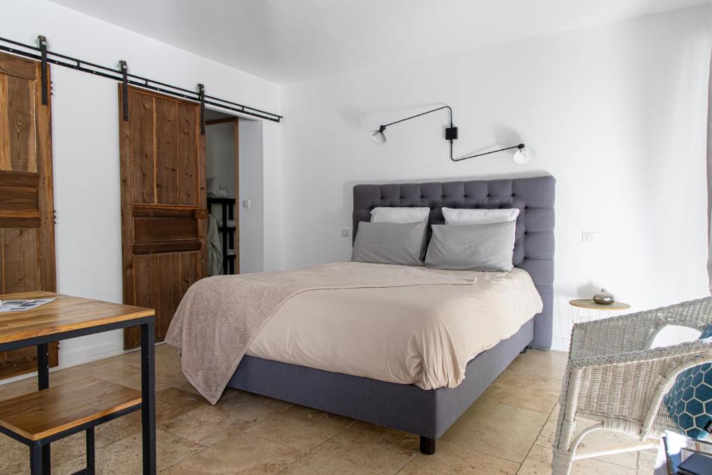 a bedroom with a large bed and a table at Mas lou Félibrige in Venelles