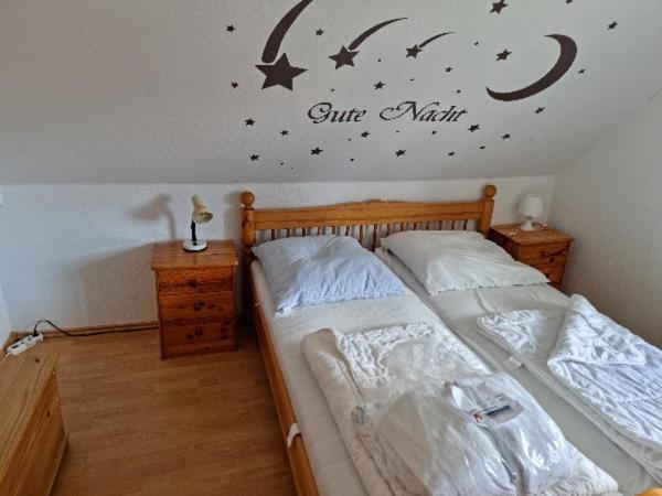 ein Schlafzimmer mit 2 Betten und einem Mond und Sternen an der Wand in der Unterkunft Kleiner Hookie in Hooksiel mit Hund in Wangerland