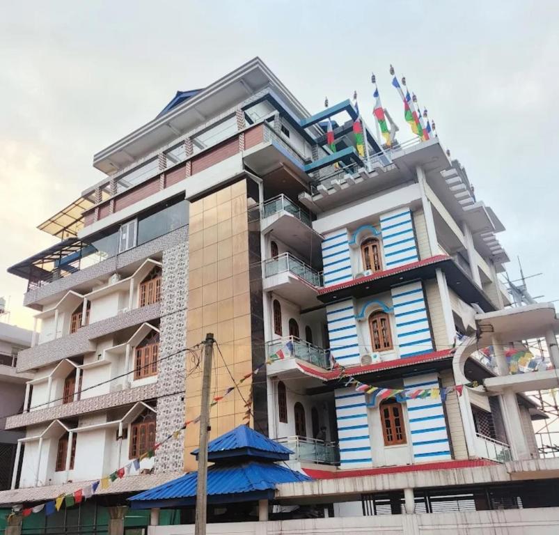 a tall building with many windows and flags on it at HOTEL SG HUB TOWER in Margherita