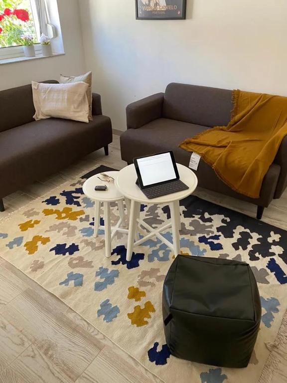 a living room with a couch and a table with a laptop at Guest House AltoNível in Viana do Castelo
