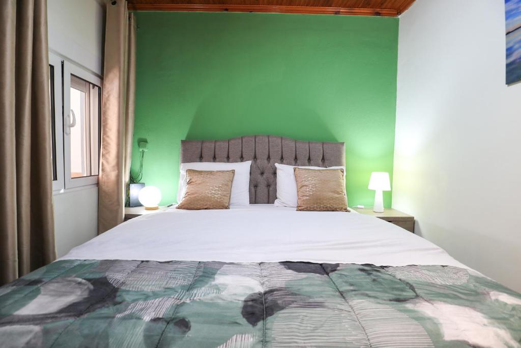 um quarto com uma cama grande e uma parede verde em Κυανή Ακτή - Agia Paraskevi em Mákri