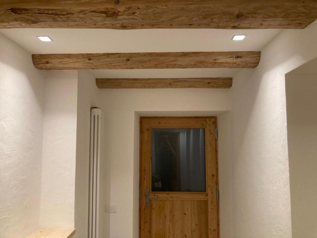 a room with a wooden door and a television at Cèsa Sès da mont in Livinallongo del Col di Lana