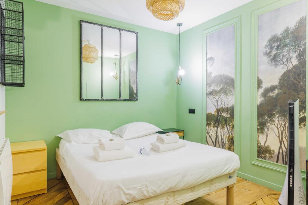 1 dormitorio con 1 cama con toallas en Chic Parisian Retreat - Porte de Montreuil - 2, en París