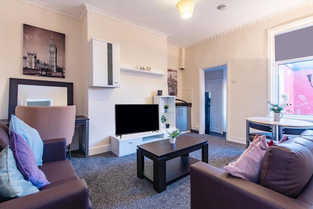 uma sala de estar com um sofá e uma televisão em Imeary - 3BR Terraced Near S. Shields em South Shields