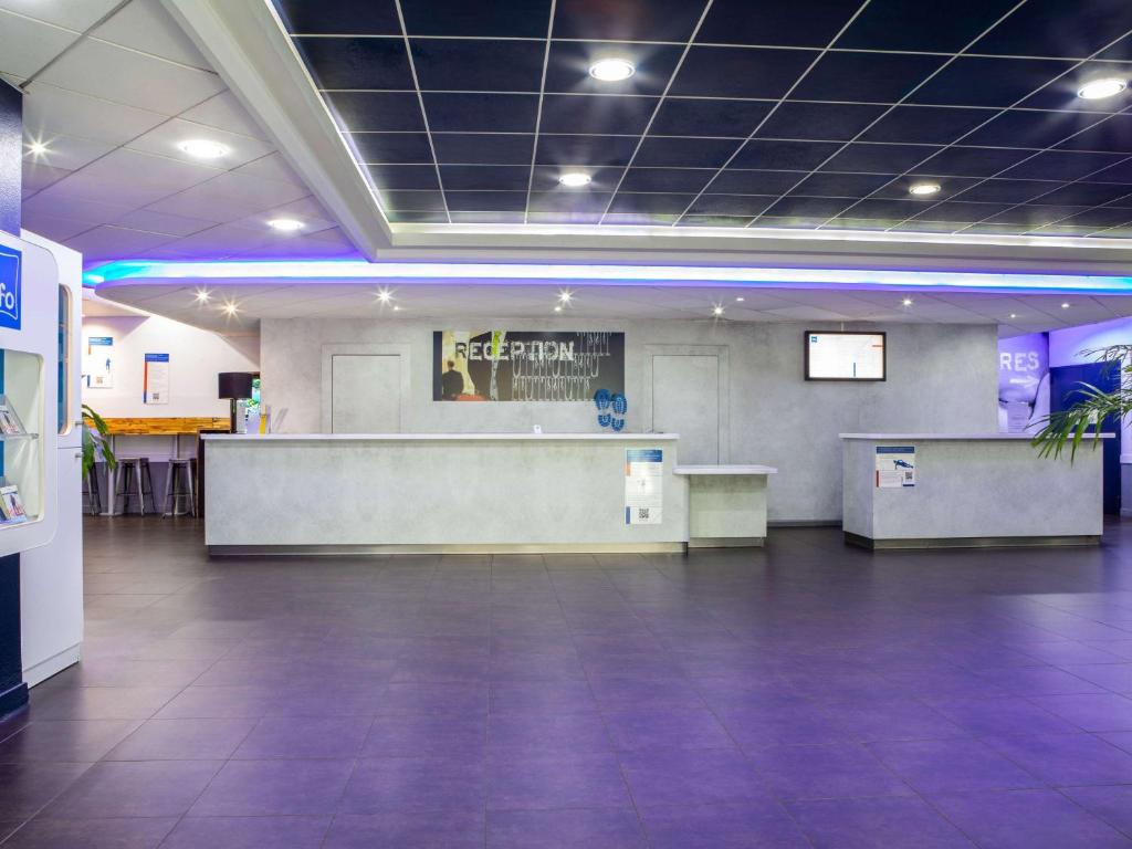 a large lobby with a waiting room with a counter at ibis budget Paris Porte De Montmartre in Paris
