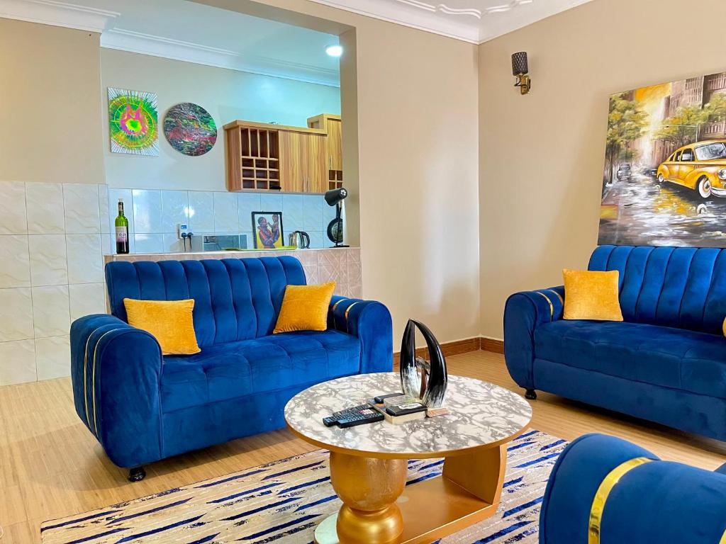 una sala de estar con sofás azules y una mesa. en TREAT HOMIES, en Kira