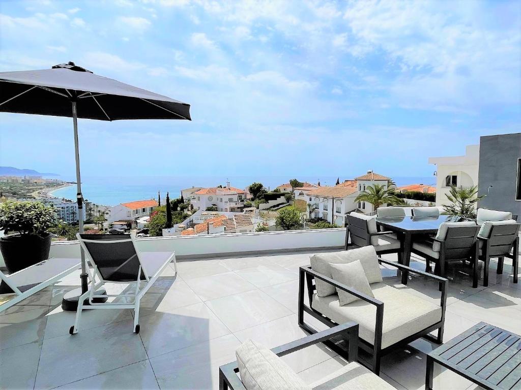 a patio with a table and chairs and an umbrella at Fantastic view near the beach in Nerja in Nerja