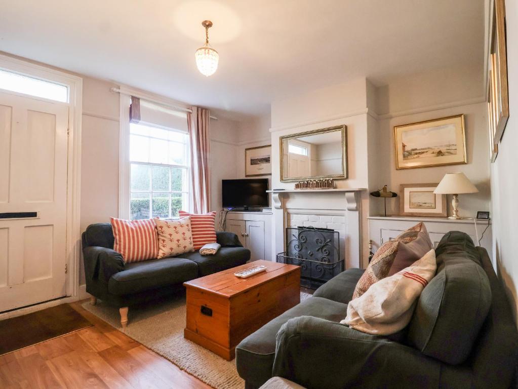 ein Wohnzimmer mit 2 Sofas und einem Kamin in der Unterkunft 3 Albion Cottages in Southwold