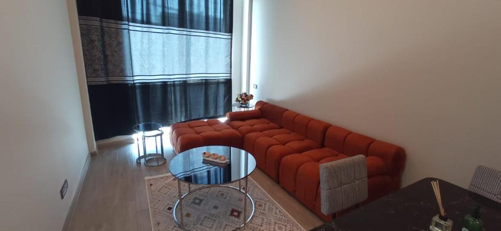 een woonkamer met een rode bank en een glazen tafel bij Luxury 1+1 bed in NG resident in Istanbul