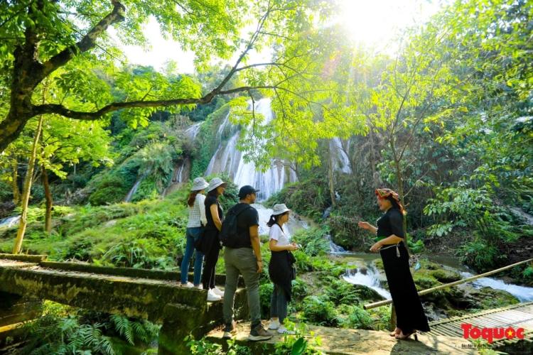 um grupo de pessoas em pé em uma ponte em uma floresta em Tua's Homestay em Mai Châu