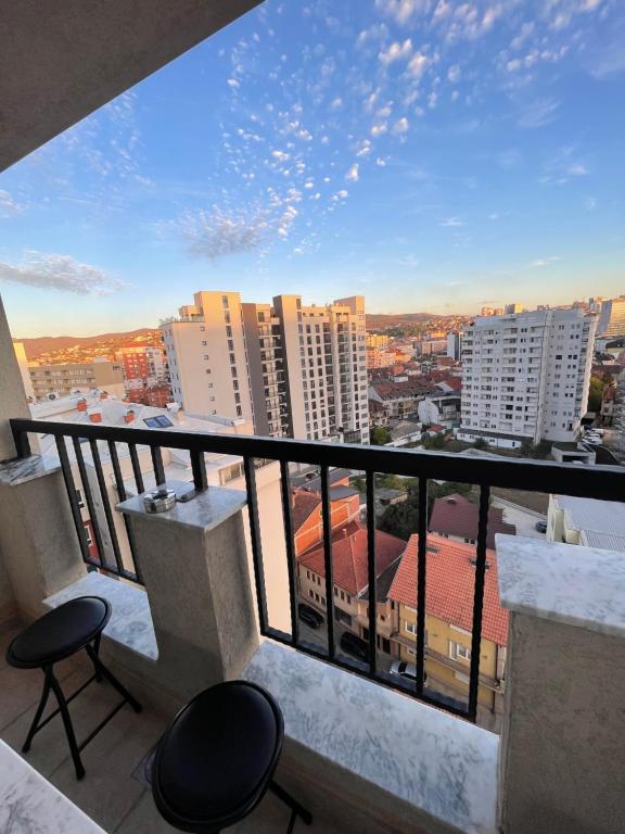 een balkon met stoelen en uitzicht op de stad bij Bright Prishtina City Apartment in Pristina