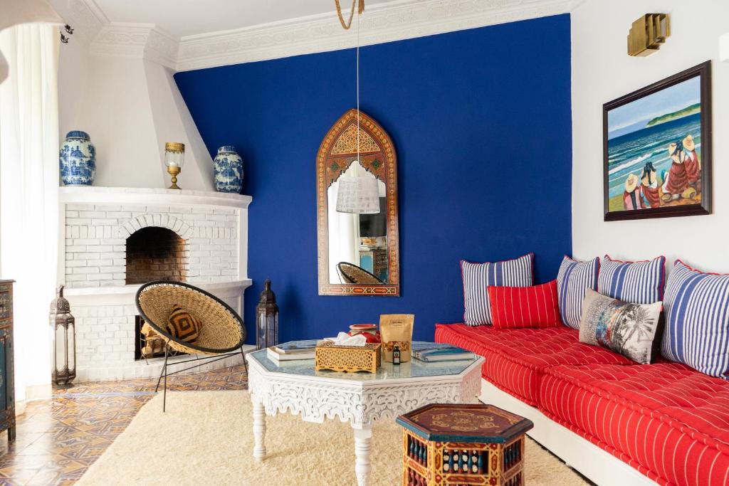 a living room with a red couch and a blue wall at Lalla Soulika in Tangier