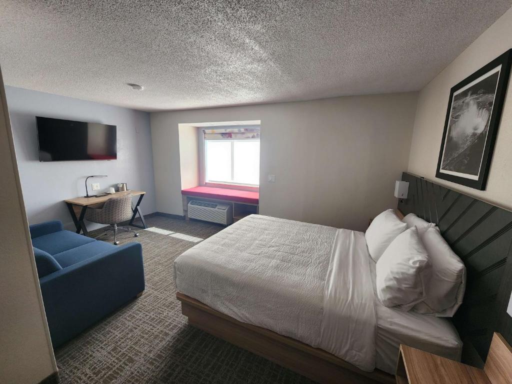 Cette chambre comprend un lit et un bureau. dans l'établissement Eva Hotel Buffalo Airport, BW Signature Collection, à Buffalo
