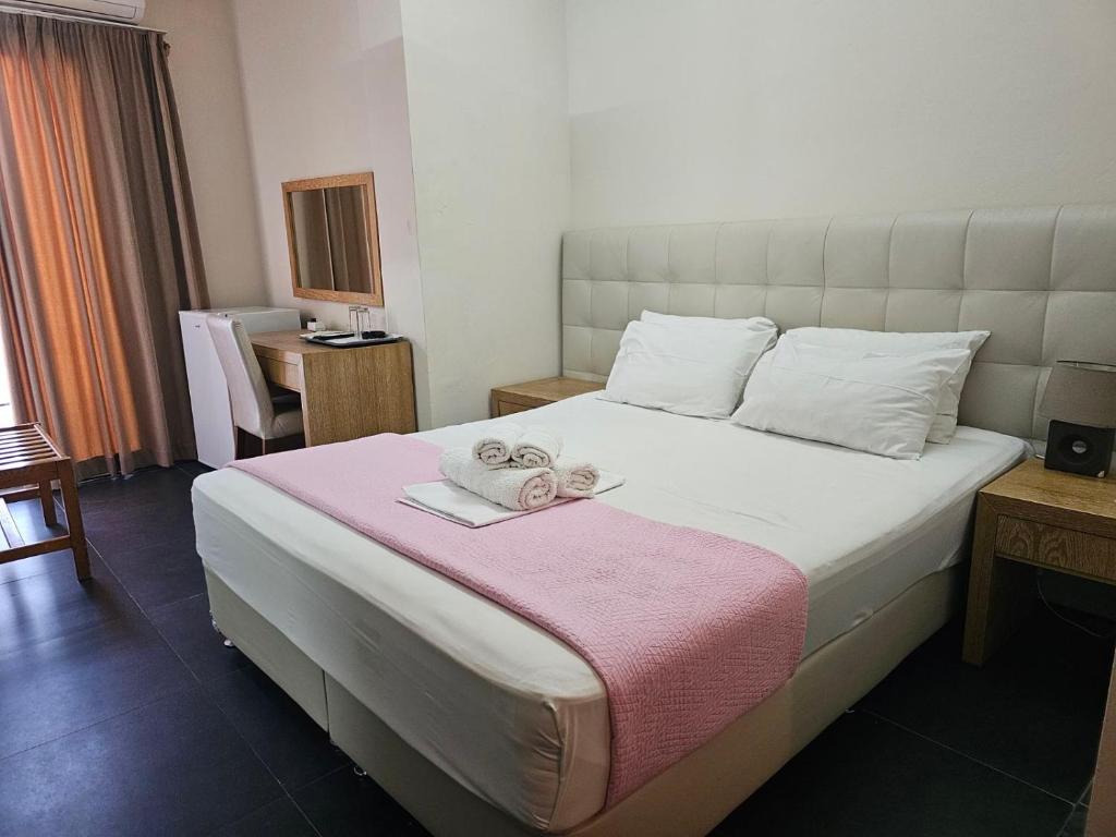 sypialnia z dużym łóżkiem z dwoma ręcznikami w obiekcie Feevos w Pireusie