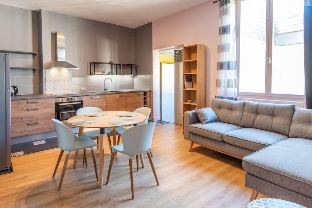 un salon avec un canapé, une table et des chaises dans l'établissement Chez Magali, à Rouen