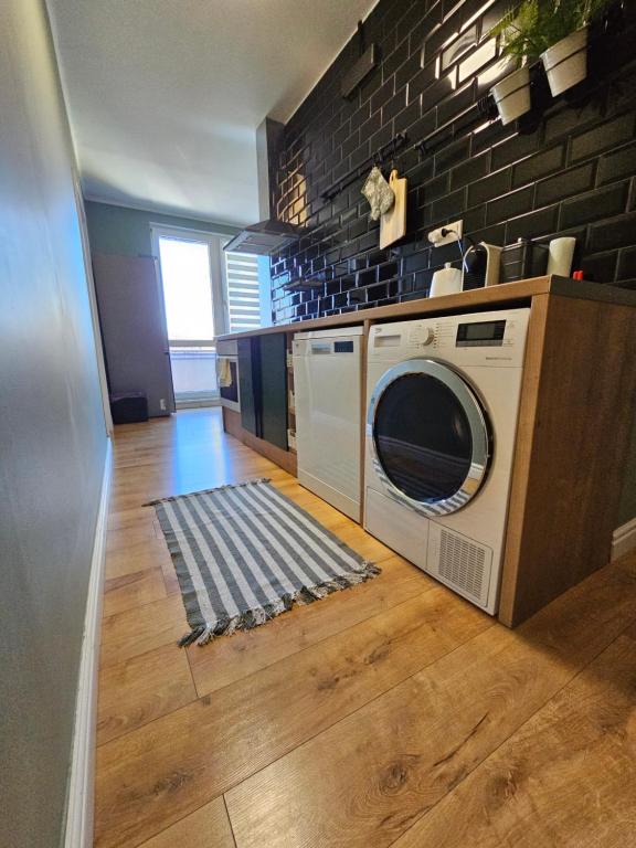 a washing machine in a kitchen with a brick wall at CENTRAL APARTMAN 7 in Komárno