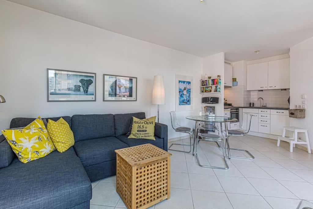 sala de estar con sofá azul y mesa en Antibes 1 bedroom close to port in modern building, en Antibes
