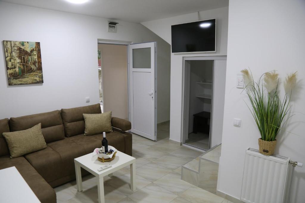 Studio T&M, sa parkingom في Obrenovac: غرفة معيشة مع أريكة وطاولة