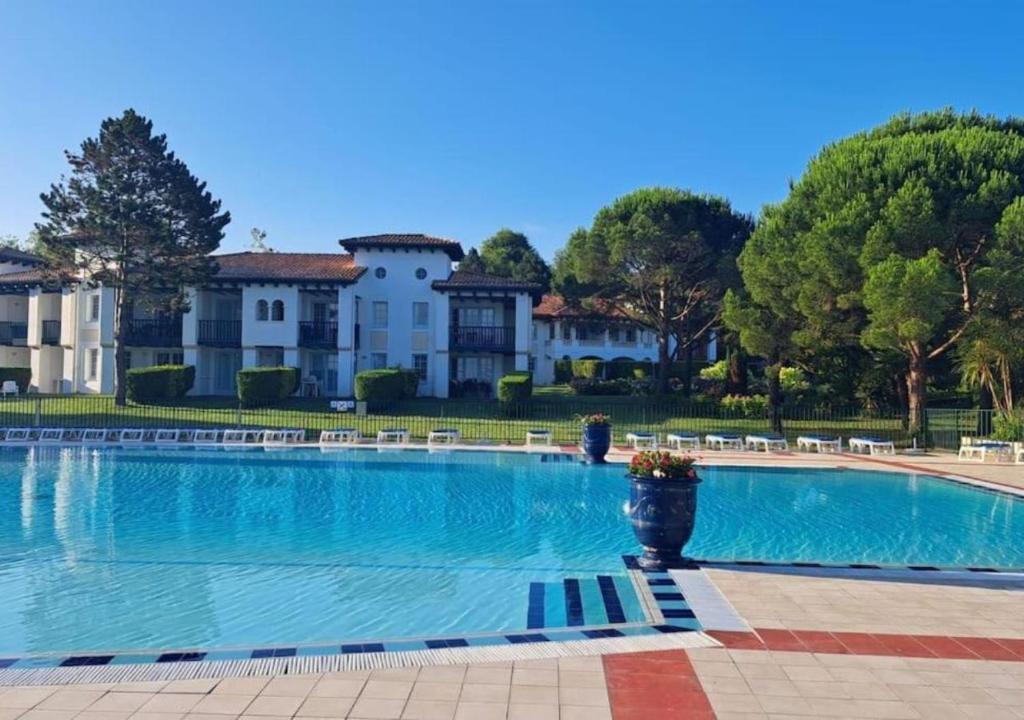 a large swimming pool in front of a large house at Domaine Bordaberry T2 Jardin et Superbe piscine in Urrugne