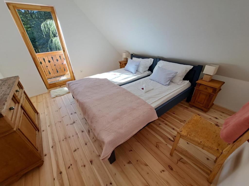 a bedroom with a bed and a wooden floor at Iluska Vendégház in Mátraszentimre