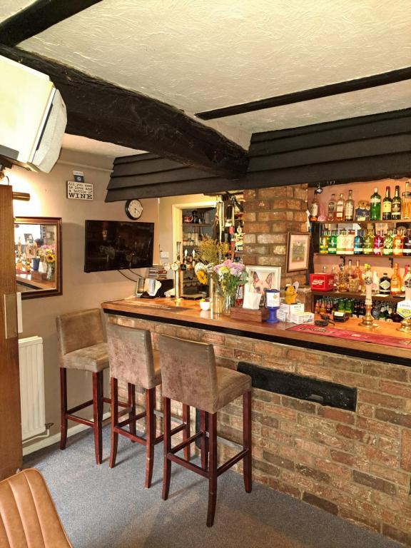 a bar in a pub with chairs around it at The Prince of Wales in Huntingdon