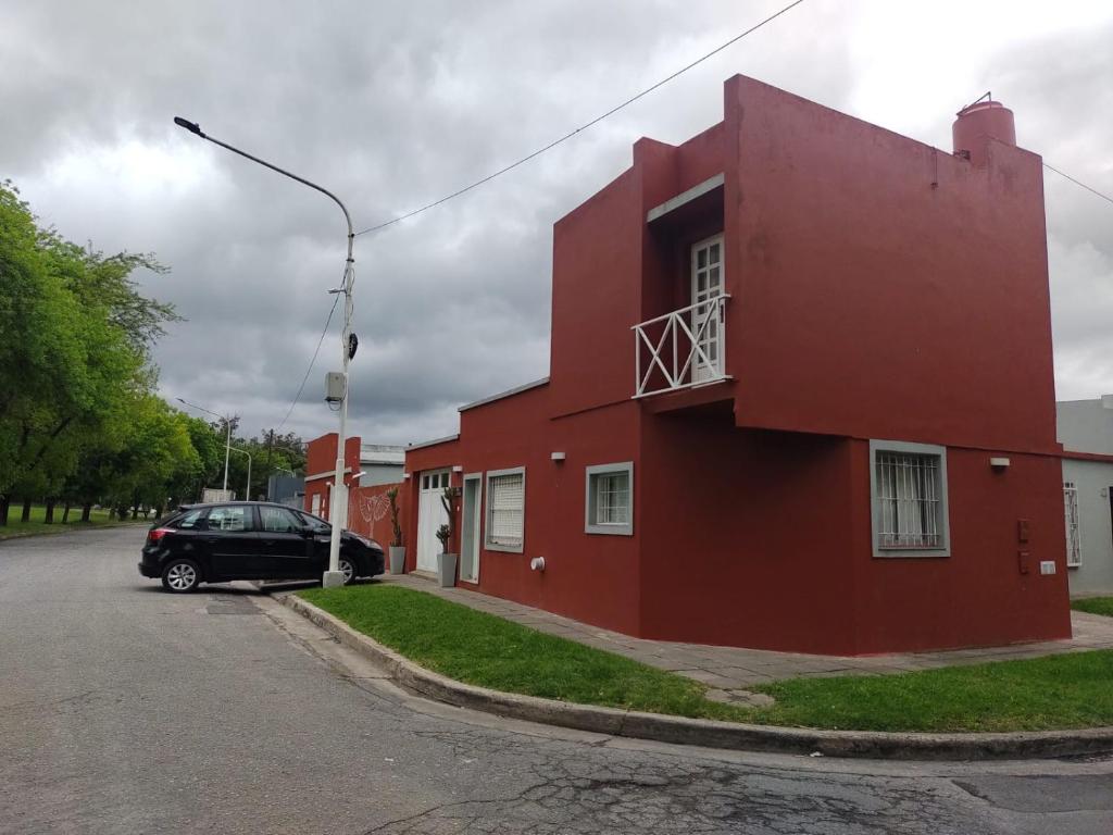 a red building with a car parked in front of it at DEPARTAMENTO UMARDA in Tandil