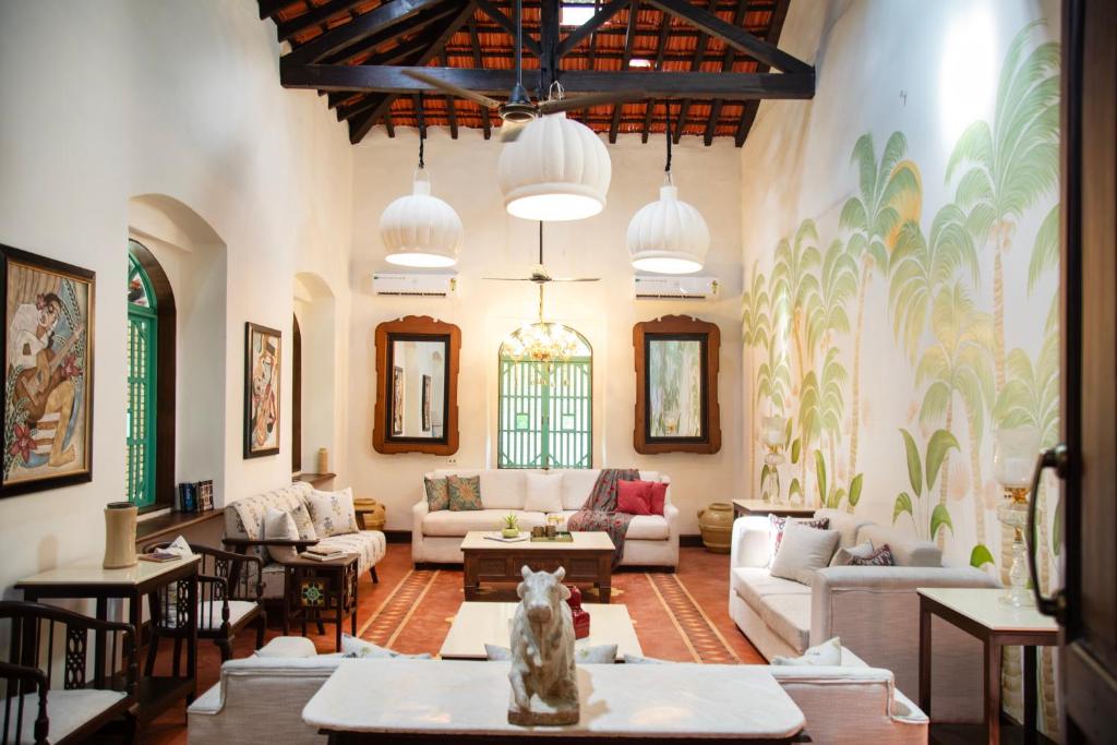 Lamrin Ucassaim Goa A 18th Century Portuguese Villa في Moira: غرفة معيشة مع أريكة وطاولة