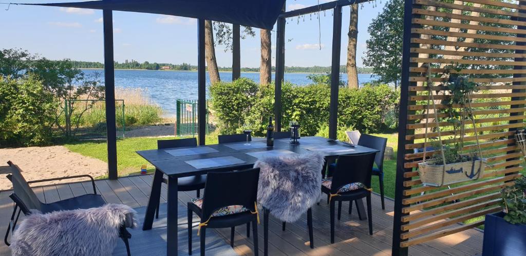 a table and chairs with a view of the water at Stacja Mazury(Masuria Station) in Narty