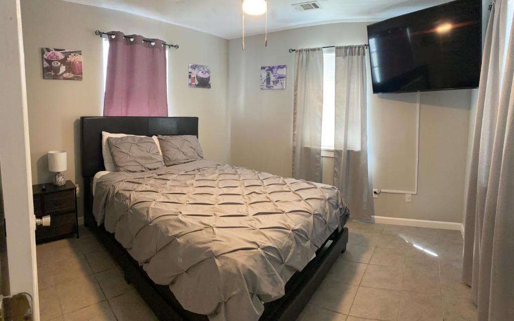 - une chambre avec un lit et une télévision dans l'établissement Jerzei Estates, à La Nouvelle-Orléans