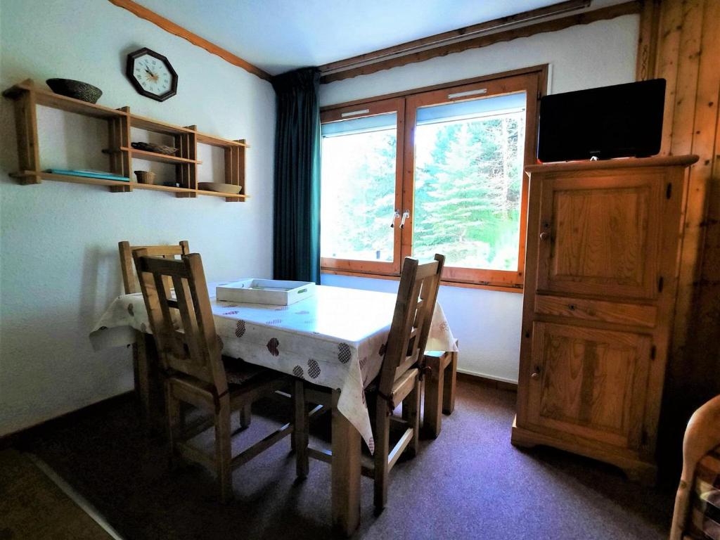 a dining room with a table and chairs and a window at Charmant studio cabine 4 pers. aux Bruyères, pied des pistes, animaux permis - FR-1-452-7 in Les Menuires