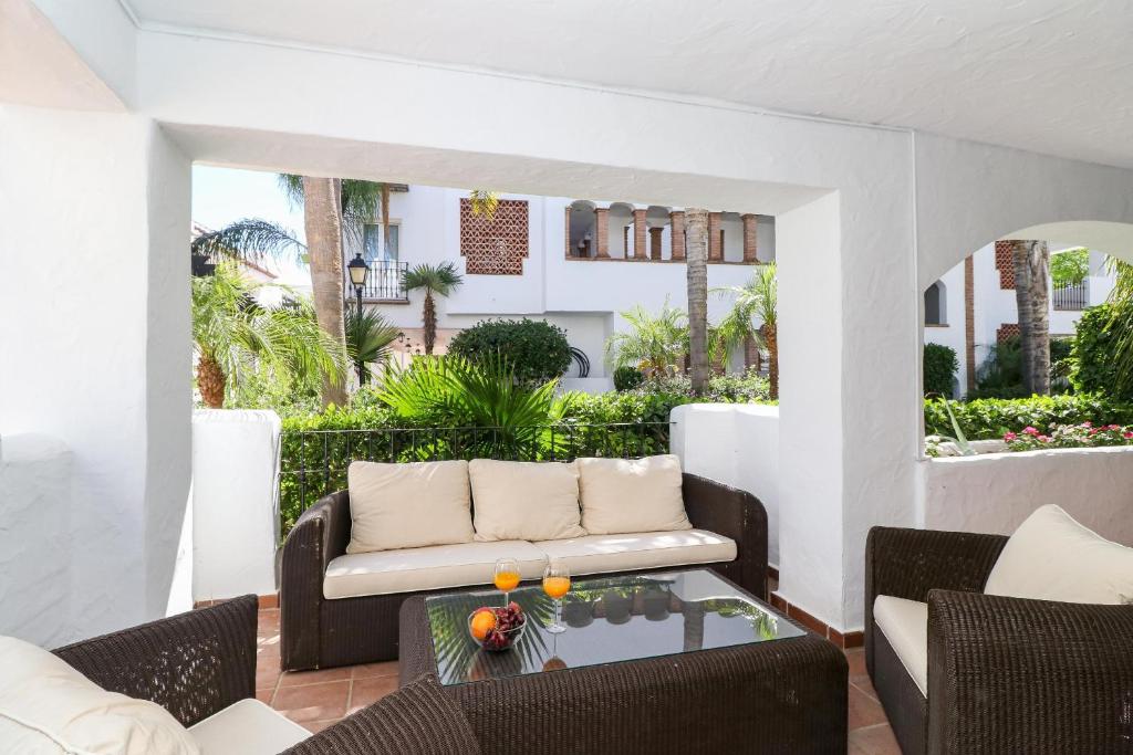 ein Wohnzimmer mit einem Sofa und einem Tisch in der Unterkunft San Pedro ground floor apartment in Marbella