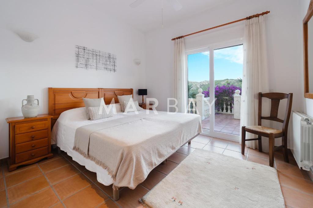 een slaapkamer met een bed en een groot raam bij Ca Adelfa in Muntanya la Sella