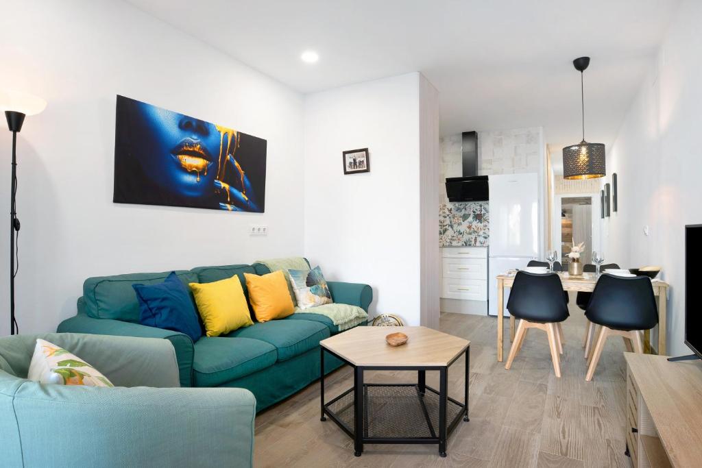 sala de estar con sofá azul y mesa en Apartamento El Músico en Barbate
