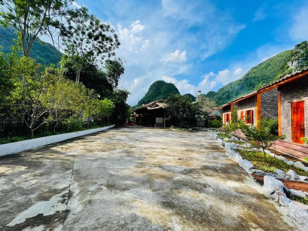 an empty road in a village with mountains at Duong Cong Chich Homestay in Lạng Sơn
