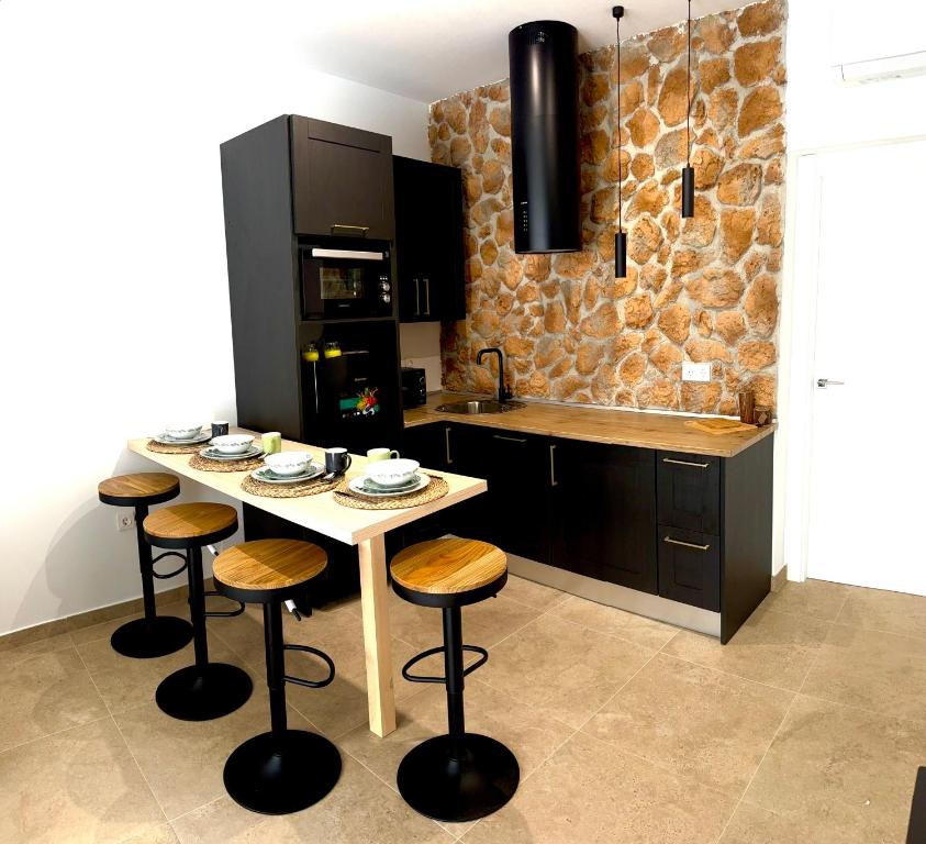 a kitchen with a table with stools and a counter at APARTAMENTO RURAL MIRADOR DE SIERRA BERMEJA in Mirandilla