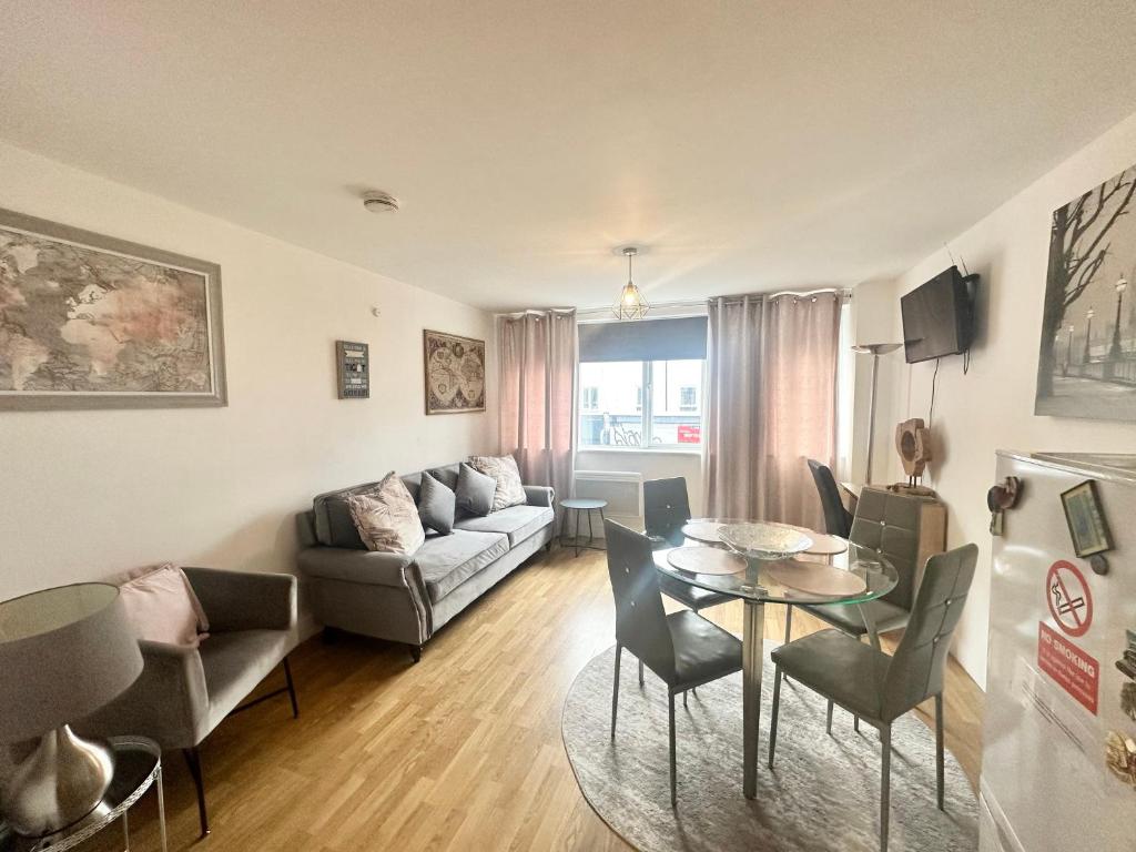 a living room with a couch and a table and chairs at London Bridge apartment in London