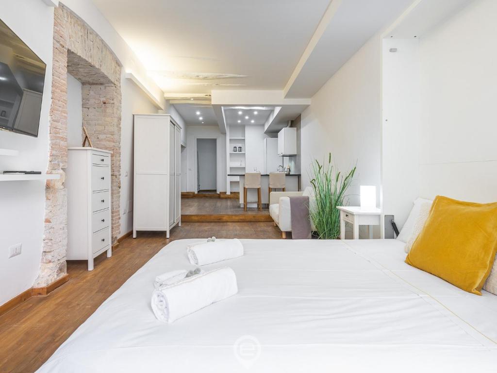 1 Schlafzimmer mit einem weißen Bett und einer Küche in der Unterkunft Old Town loft in Cagliari