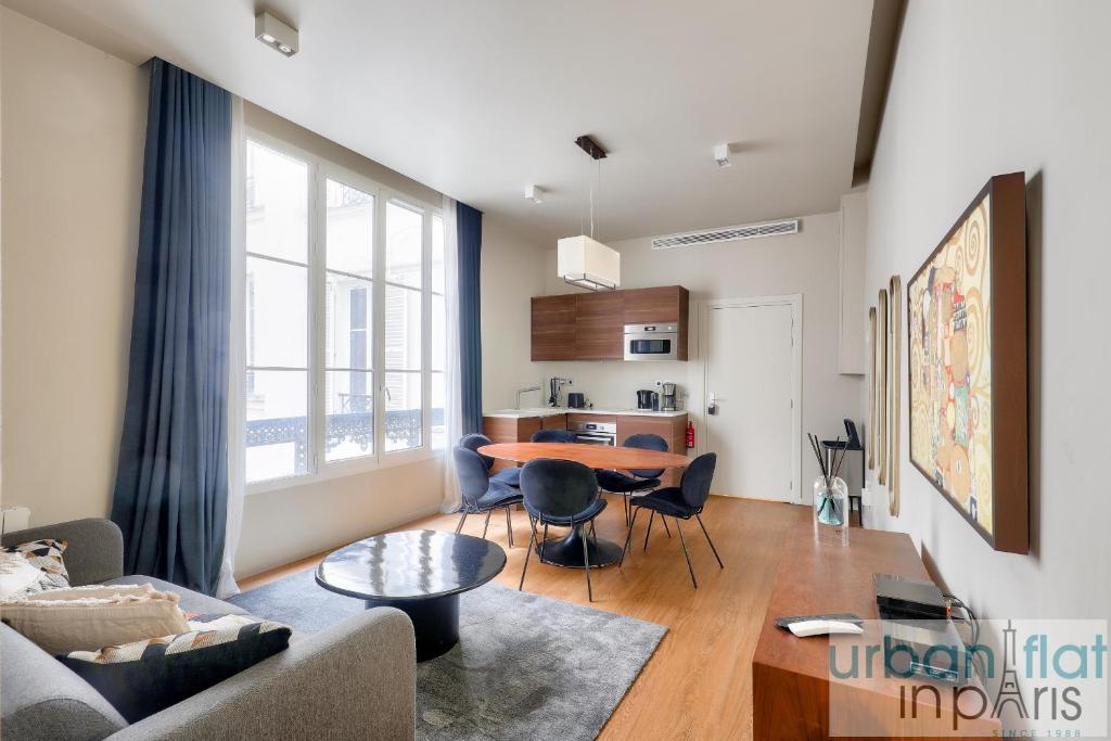 un salon avec une table et un canapé dans l'établissement Urban Flat 110 - Luxury 3BDR Flat near Opera Paris, à Paris