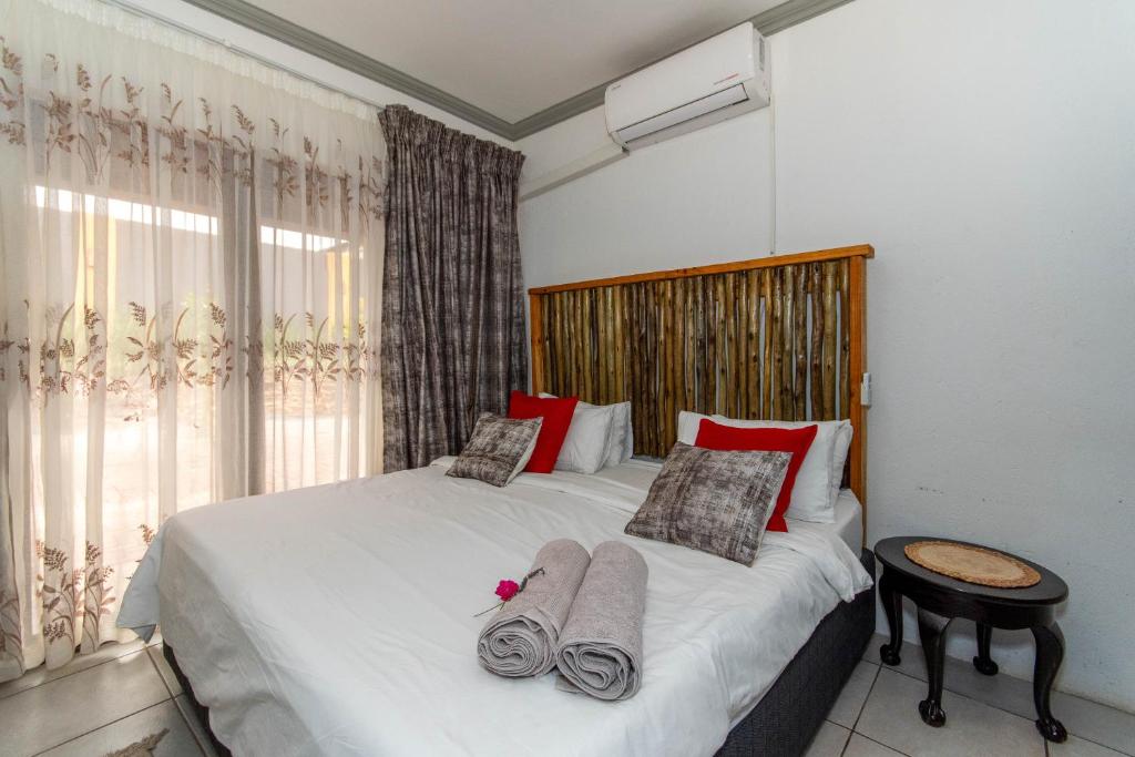 ein Schlafzimmer mit einem Bett mit Handtüchern darauf in der Unterkunft Woodpeckers Guest House in Hazyview