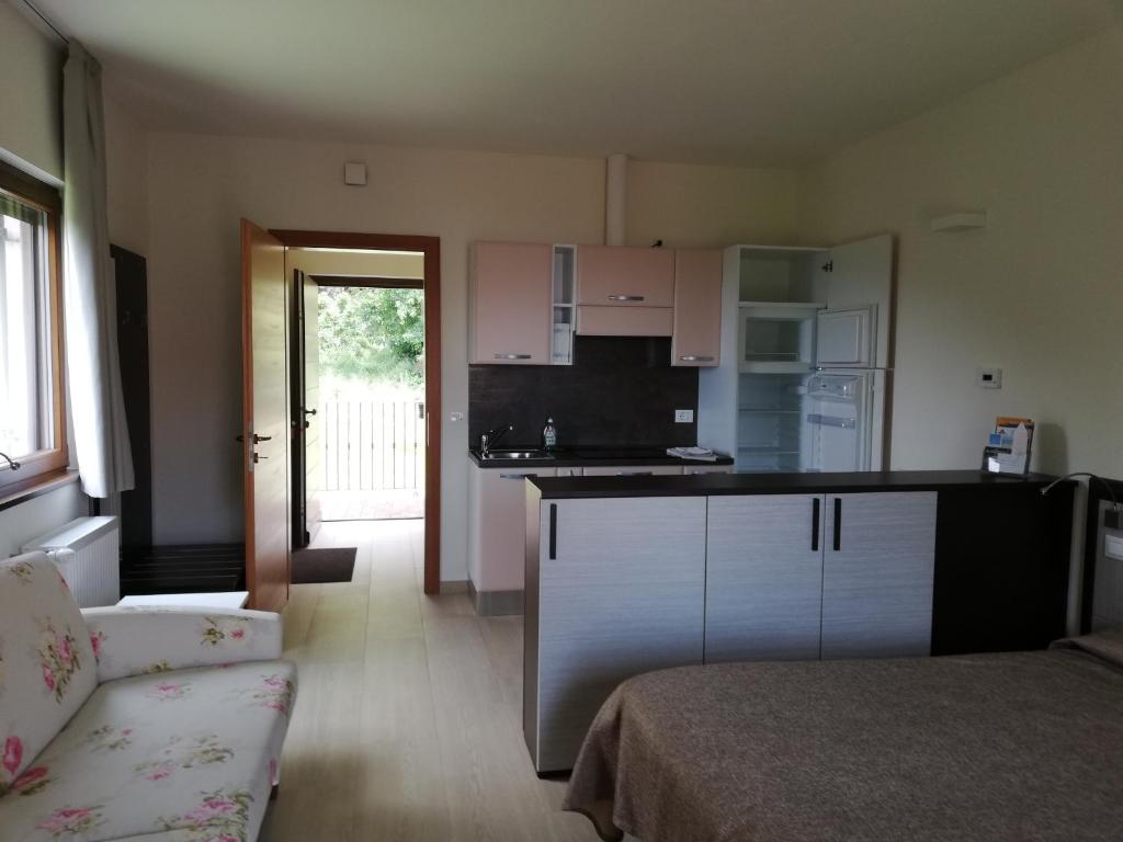 a kitchen with white cabinets and a couch in a room at Casabrin in Trivero
