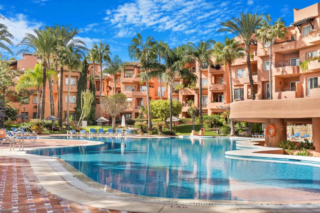 - une piscine dans un complexe avec des palmiers dans l'établissement Oasis de Marbella, à Marbella