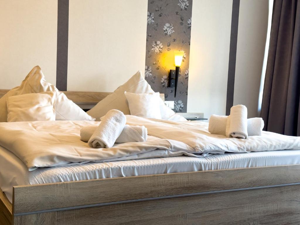 a bed with white blankets and pillows on it at Hotel Wernerwald in Cuxhaven
