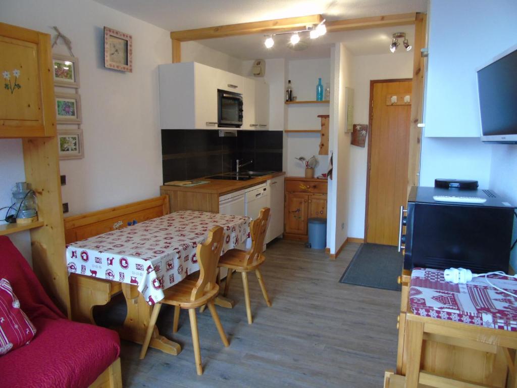 a kitchen with a table and chairs and a kitchen with a table and a kitchen at Studio Valfréjus, 1 pièce, 4 personnes - FR-1-561-8 in Valfréjus
