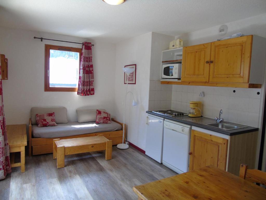 une petite cuisine avec un canapé et une table dans l'établissement Appartement cozy 6 pers., 50m écoles ski, WIFI, parking, balcon - FR-1-561-18, à Valfréjus