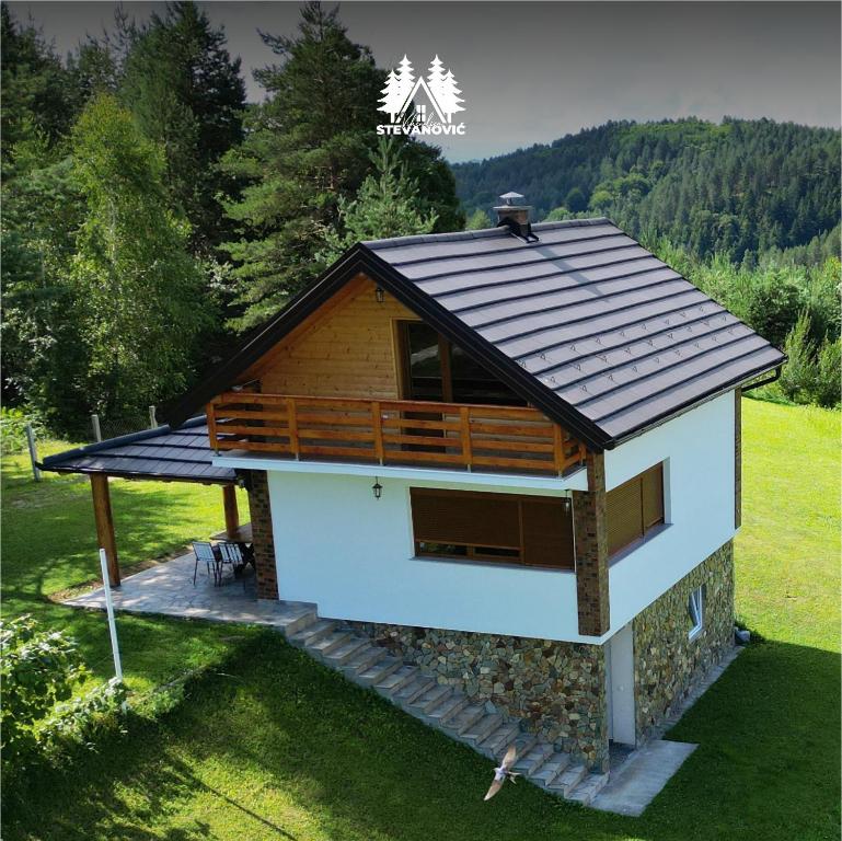 ein kleines Haus mit einem Dach auf einem Feld in der Unterkunft Vikendica Stevanovic in Doboj