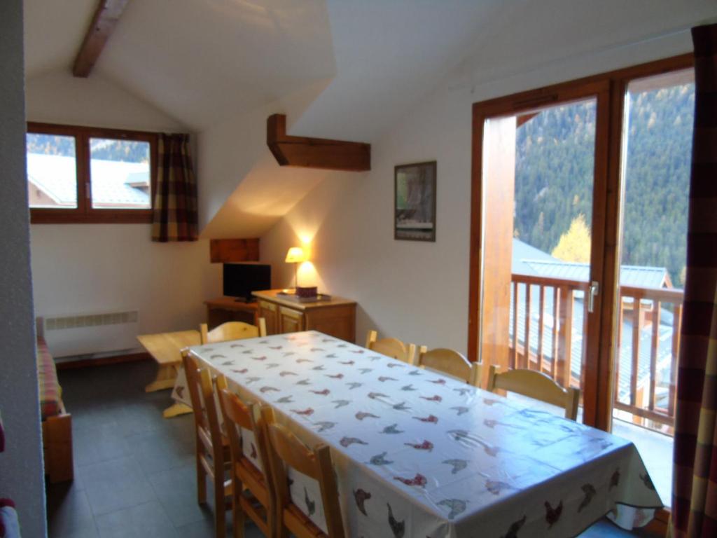 a room with a table and chairs and a balcony at Appartement Valfréjus, 4 pièces, 8 personnes - FR-1-561-27 in Valfréjus