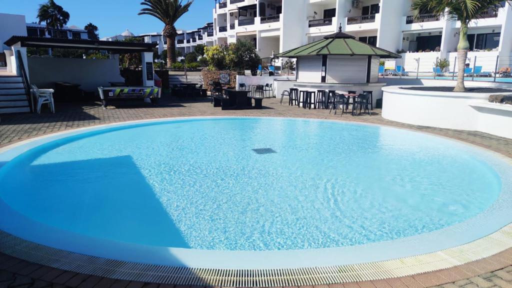 une grande piscine bleue à côté d'un bâtiment dans l'établissement Blue Ocean, à Costa Teguise