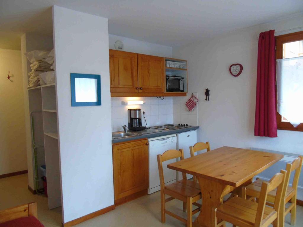 a kitchen with a wooden table and a table and chairs at Appartement Valfréjus, 2 pièces, 4 personnes - FR-1-561-36 in Valfréjus