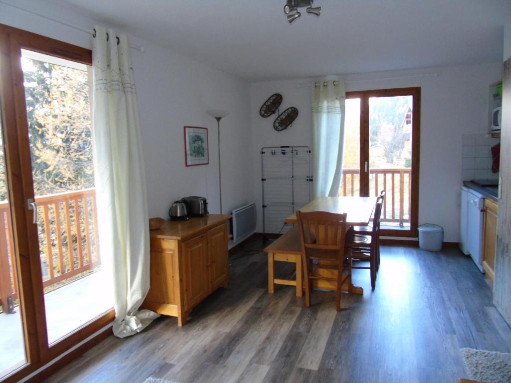 une cuisine avec une table et des chaises ainsi qu'une salle à manger dans l'établissement Appartement cosy 2 P+Cabine pour 6, proche pistes et commerces, vue Parc Vanoise - FR-1-561-48, à Valfréjus