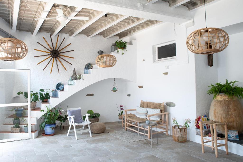 a room with a staircase and chairs and potted plants at Hostal el Ranxo in Cadaqués